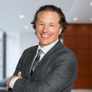 Man in dark grey suite and plaid tie